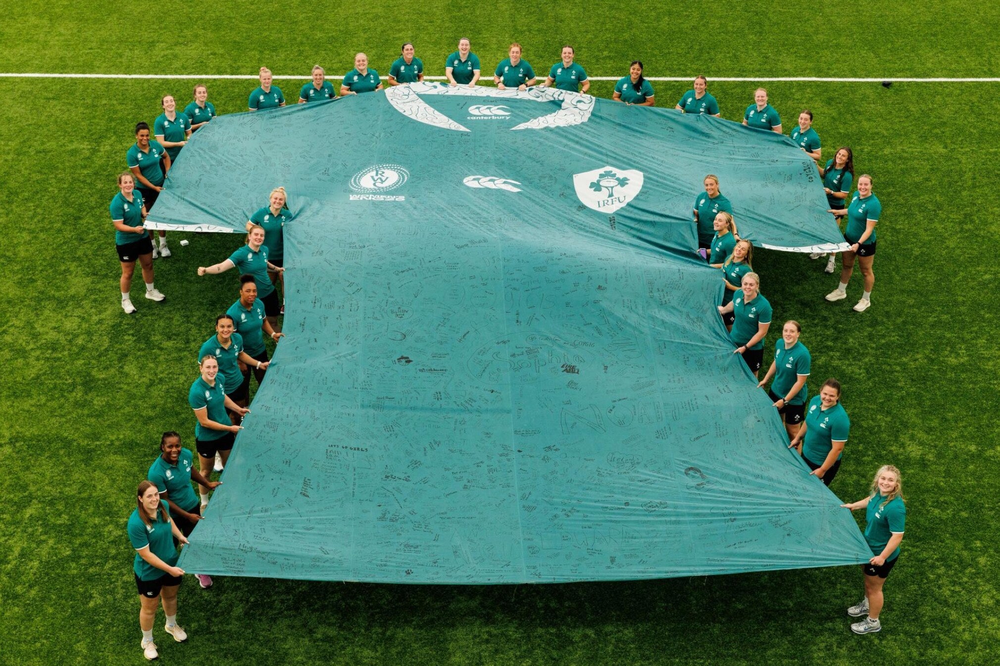 Ireland Women’s Rugby team holding the giant fan-signed jersey